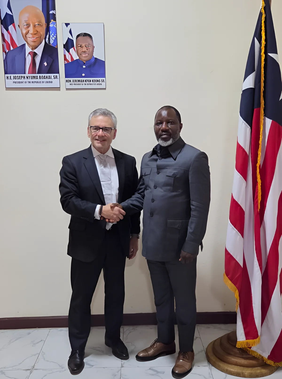 A GCG Global Forum meeting beside the flag of Liberia